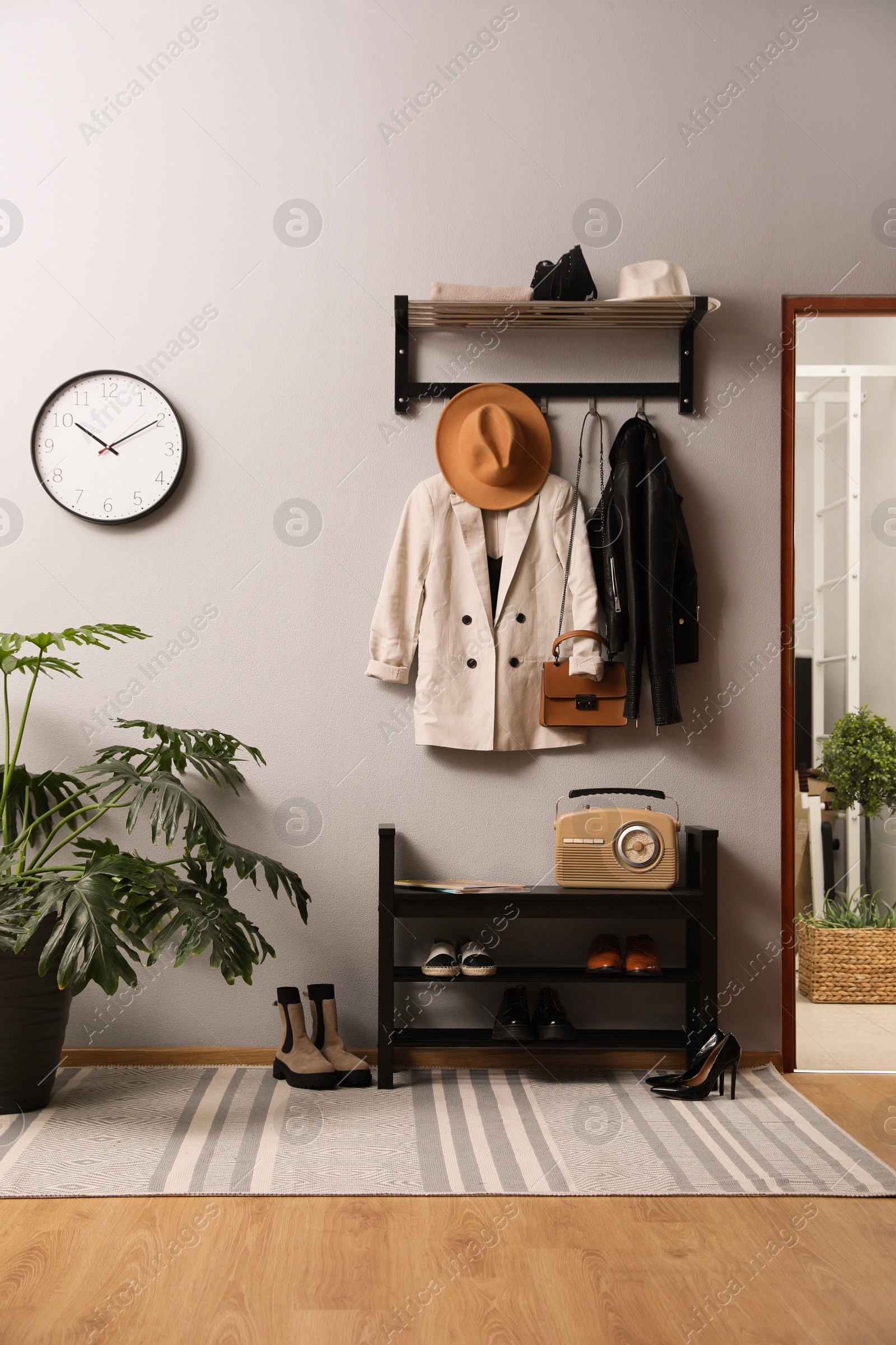 Photo of Hallway interior with stylish furniture, clothes and accessories