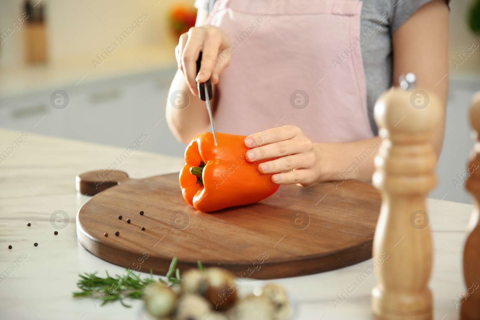 Photo of Young woman cooking at table in kitchen, closeup