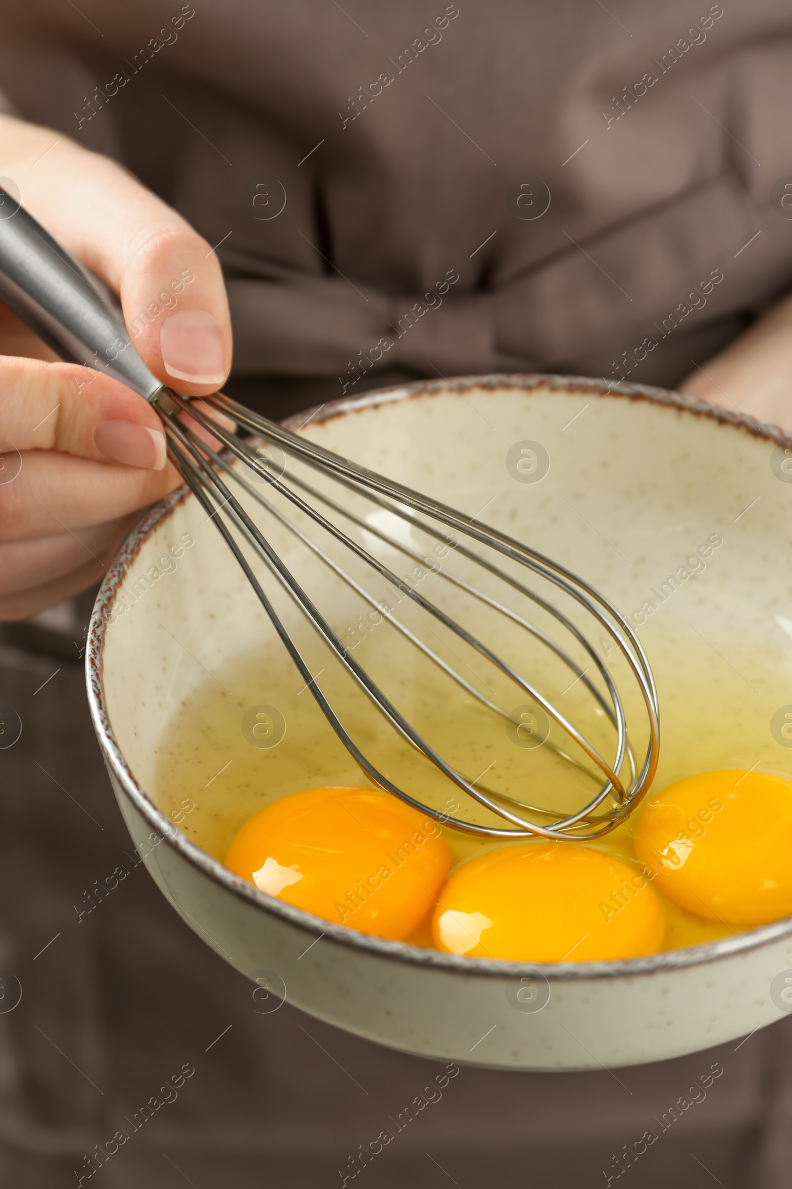 Photo of Woman whisking eggs in bowl, closeup view