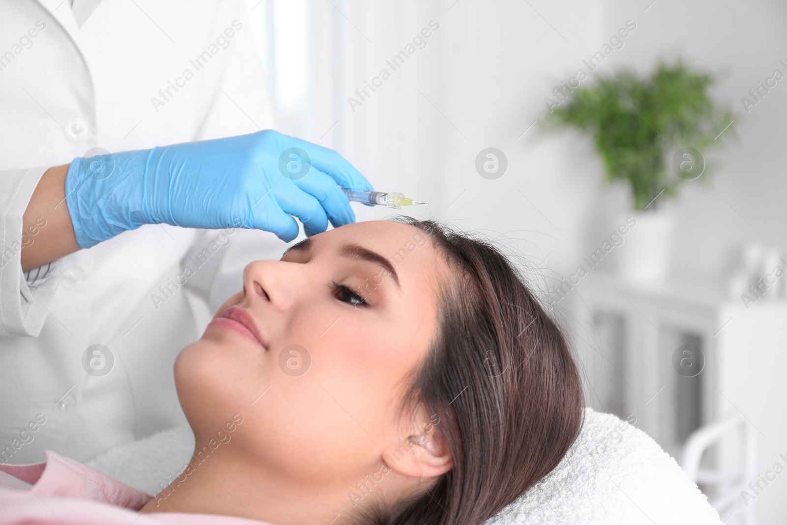 Photo of Young woman with hair loss problem receiving injection in salon