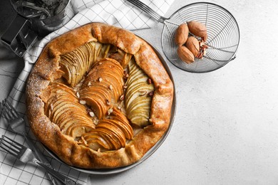 Photo of Delicious apple galette with pecans and forks on light gray textured table, flat lay. Space for text