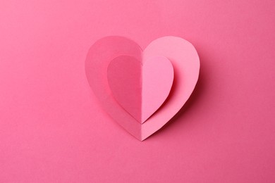 Paper hearts on pink background, top view