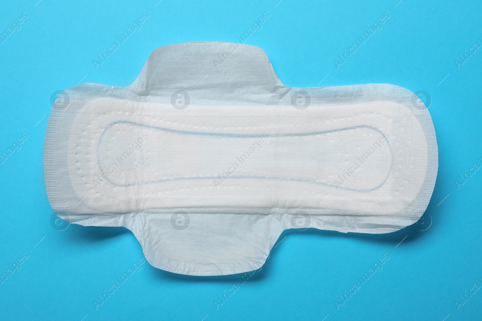 Photo of Sanitary napkin on light blue background, top view. Gynecology concept