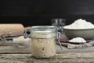 Leaven in glass jar on wooden table