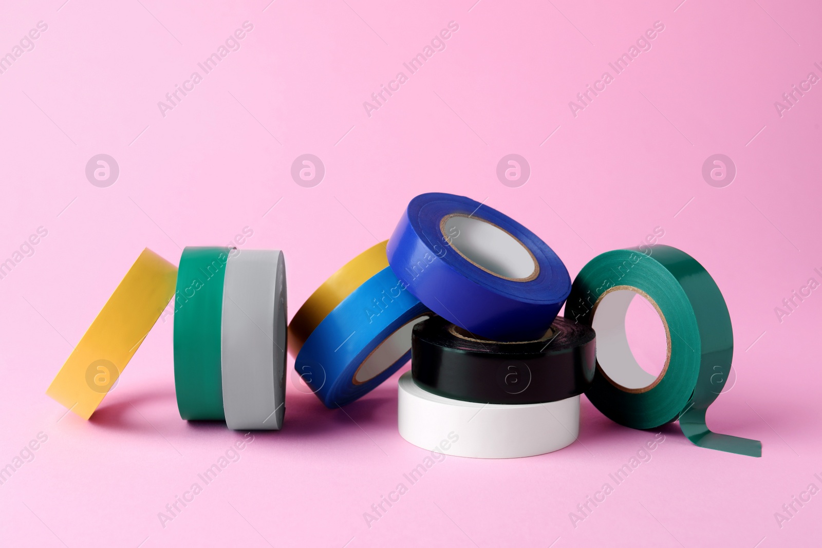 Photo of Colorful insulating tapes on pink background. Electrician's supplies