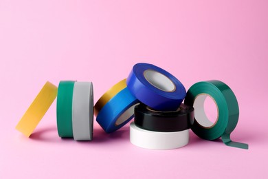 Photo of Colorful insulating tapes on pink background. Electrician's supplies