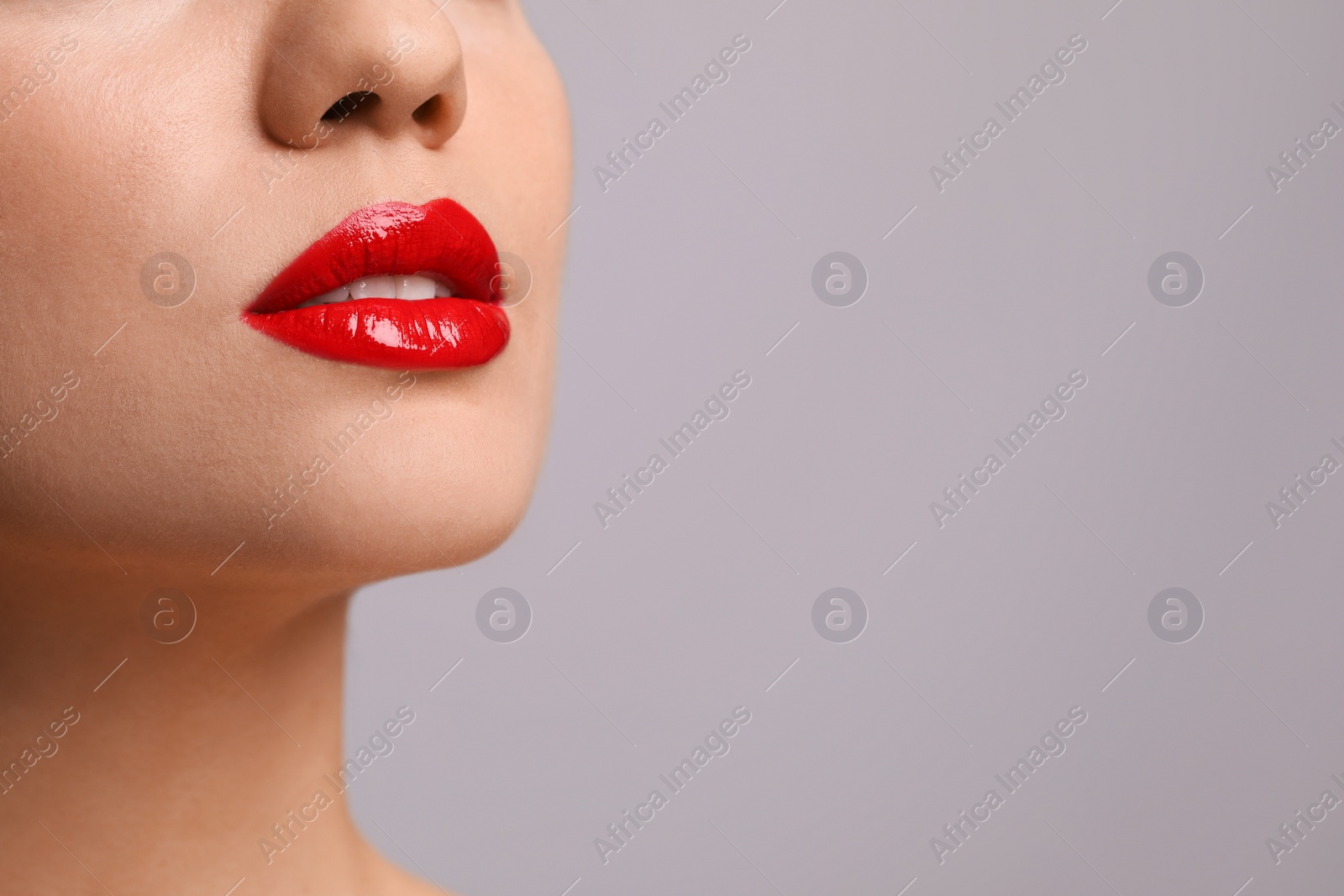 Photo of Closeup view of woman with beautiful full lips on grey background. Space for text