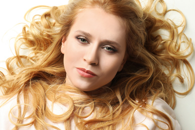 Portrait of beautiful young woman with dyed long hair on white background, top view