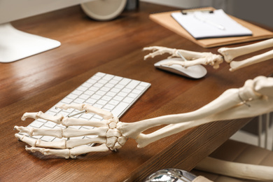 Human skeleton at table in office, closeup