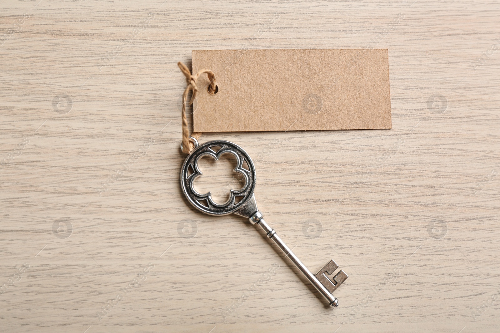 Photo of Key with blank tag on wooden table, top view. Keyword concept