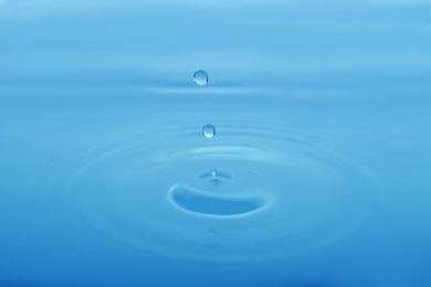 Photo of Splash of blue water with drop as background, closeup
