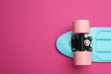 Photo of Skateboard on crimson background, top view. Space for text