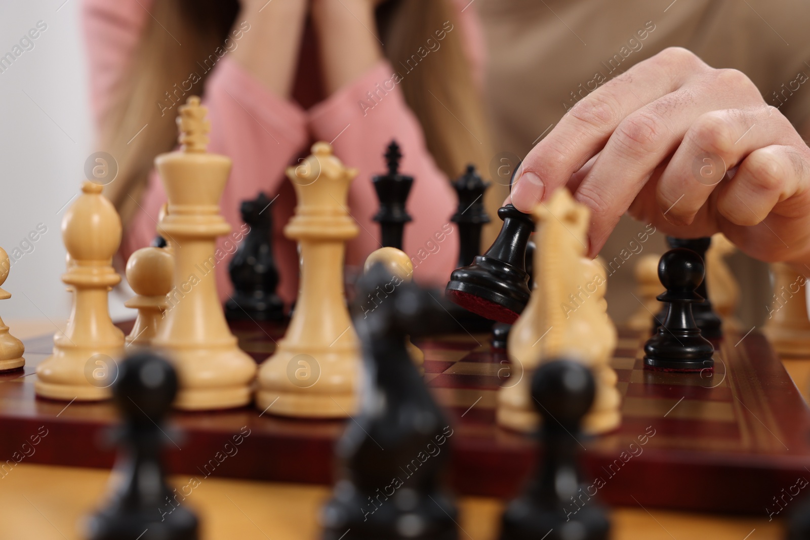 Photo of Father teaching his daughter to play chess, closeup