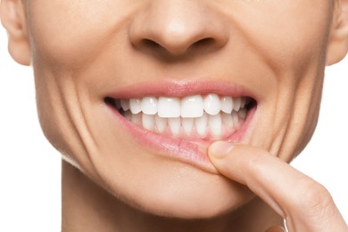 Woman showing healthy gums on white background, closeup