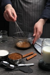 Woman whipping cream for dalgona coffee at grey table, closeup