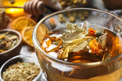Photo of Freshly brewed tea and dried herbs, closeup