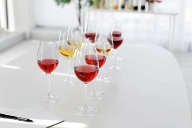 Photo of Glasses with delicious wine on table indoors