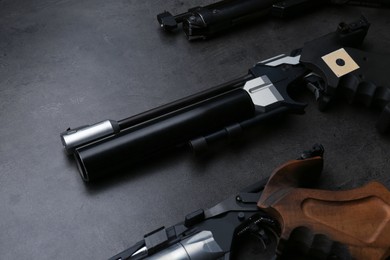 Photo of Different sport pistols on black table. Professional guns