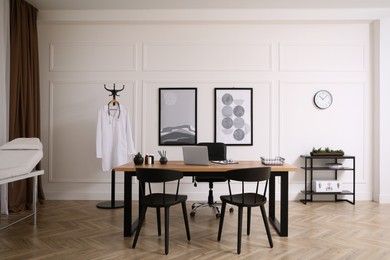 Modern medical office interior with doctor's workplace and examination table