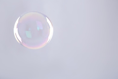 Photo of Beautiful translucent soap bubble on grey background. Space for text