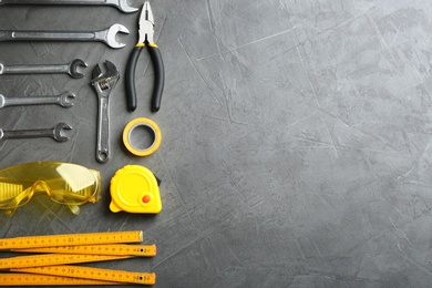 Photo of Flat lay composition with construction tools on grey background, space for text