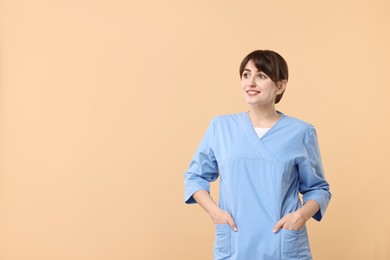 Photo of Portrait of smiling medical assistant on beige background. Space for text