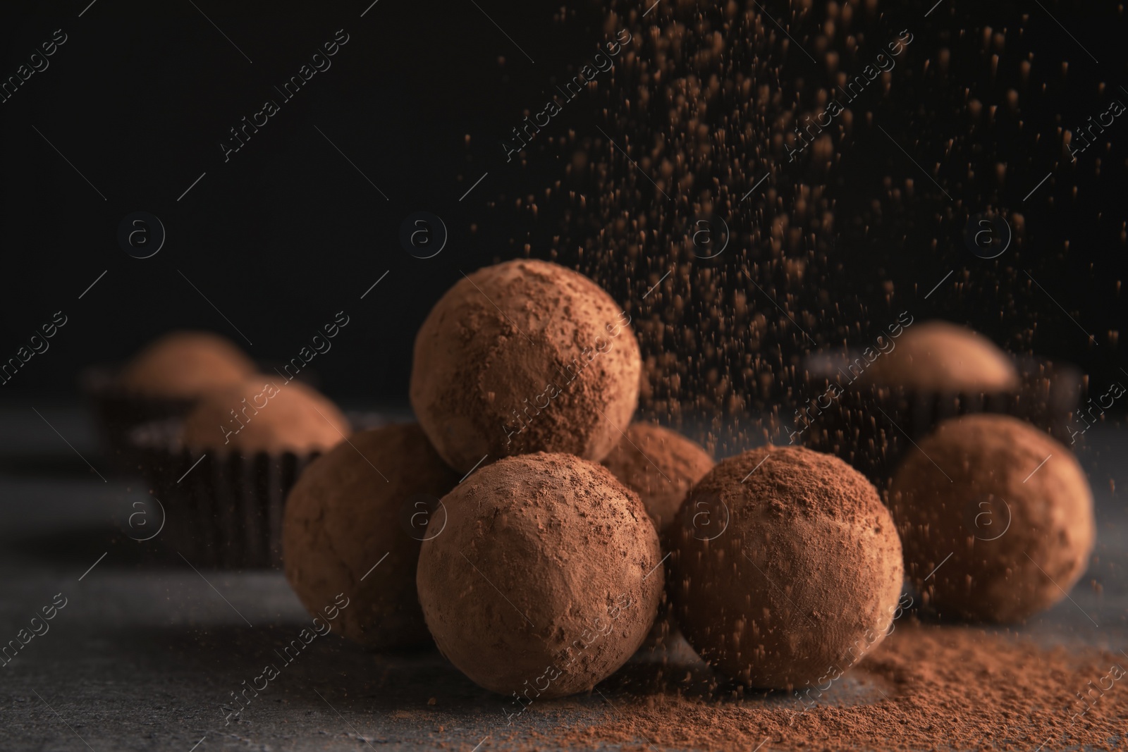 Photo of Tasty chocolate truffles powdered with cocoa on table