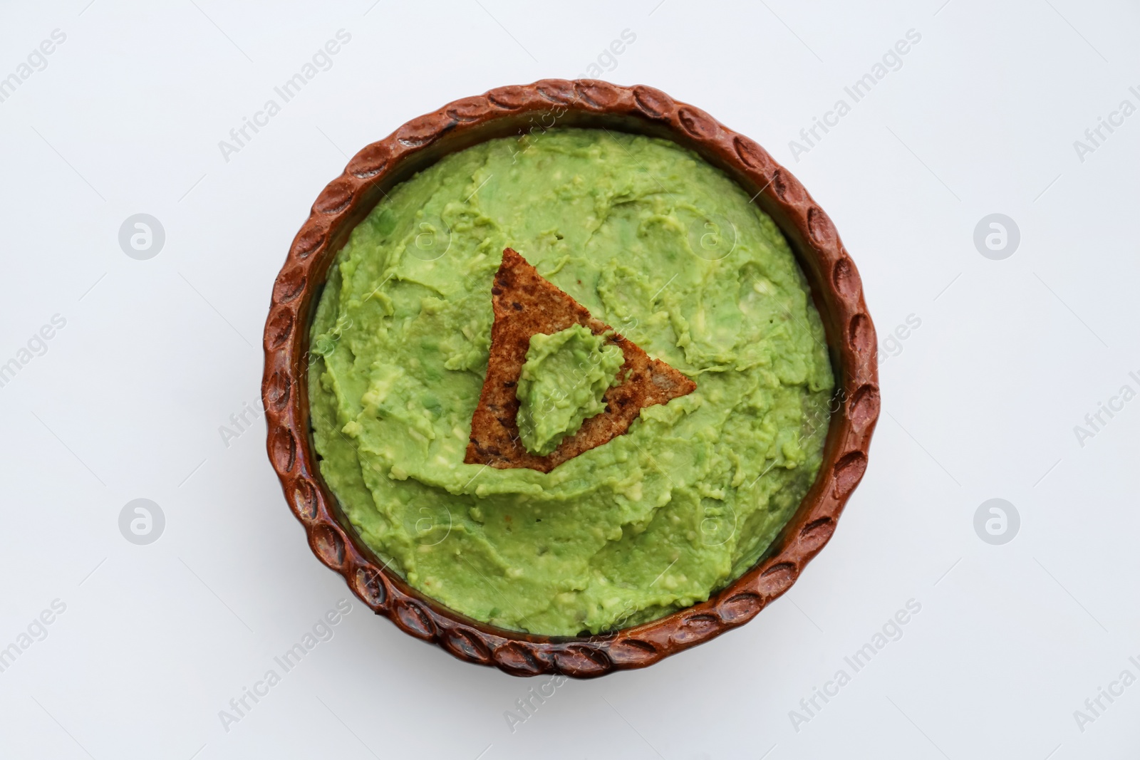 Photo of Delicious guacamole made of avocados with nachos on white background, top view