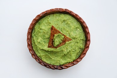 Delicious guacamole made of avocados with nachos on white background, top view