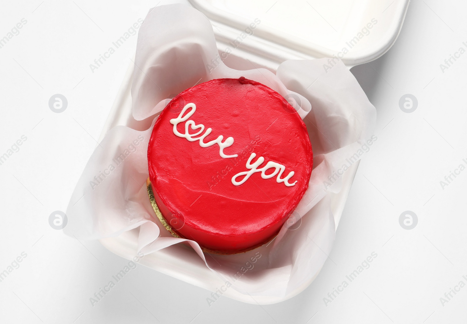 Photo of Bento cake with Love You text in takeaway box on white table, top view. St. Valentine's day surprise