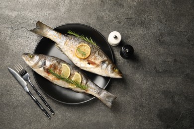 Photo of Delicious baked fish served on grey table, flat lay. Space for text