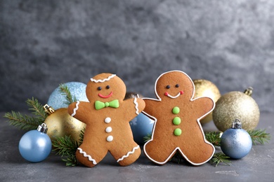 Photo of Gingerbread people and Christmas decor on grey table