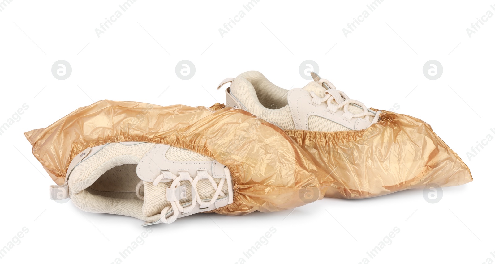 Photo of Sneakers in brown shoe covers isolated on white