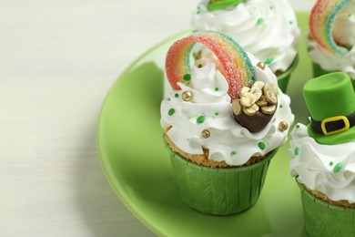 Photo of St. Patrick's day party. Tasty festively decorated cupcakes on white table, closeup. Space for text