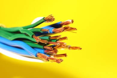 Electrical wires on yellow background, closeup. Space for text