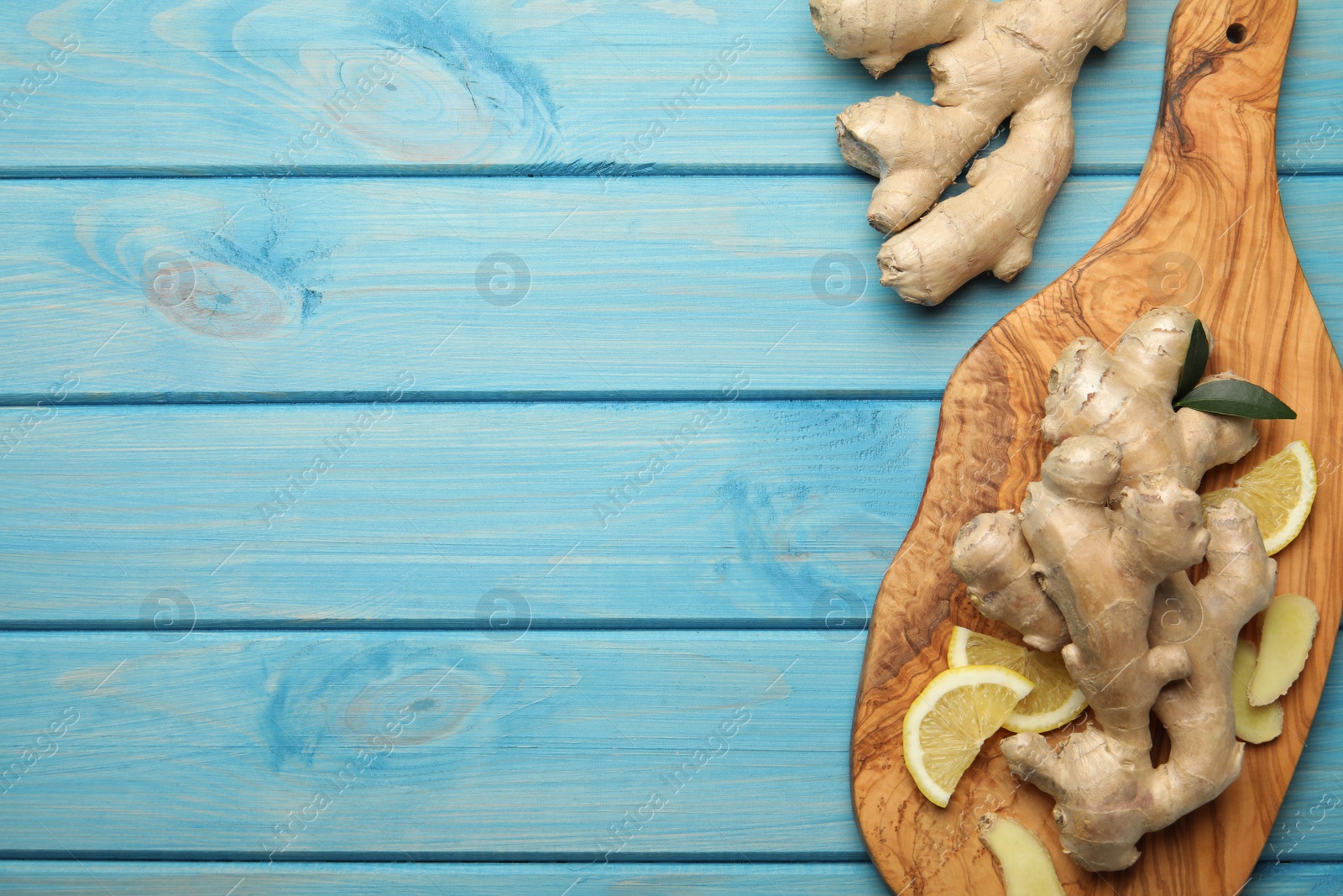 Photo of Fresh lemon and ginger on light blue wooden table, flat lay. Space for text