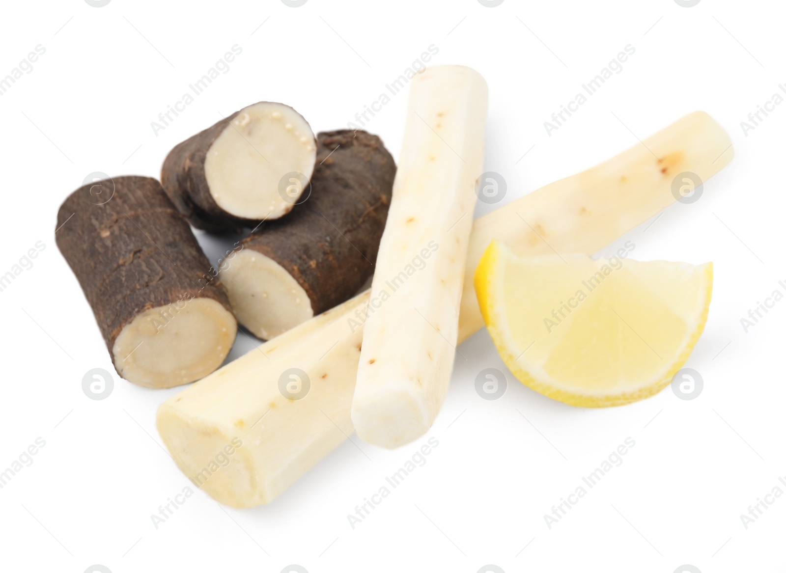 Photo of Cut raw salsify roots and lemon isolated on white