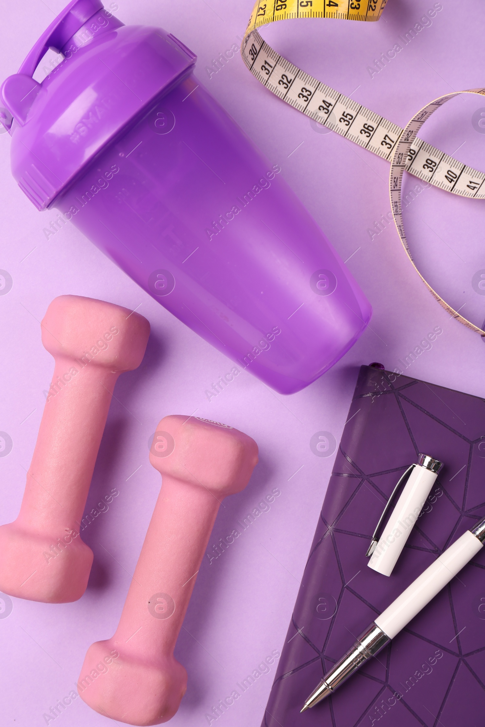 Photo of Flat lay composition with dumbbells on violet background