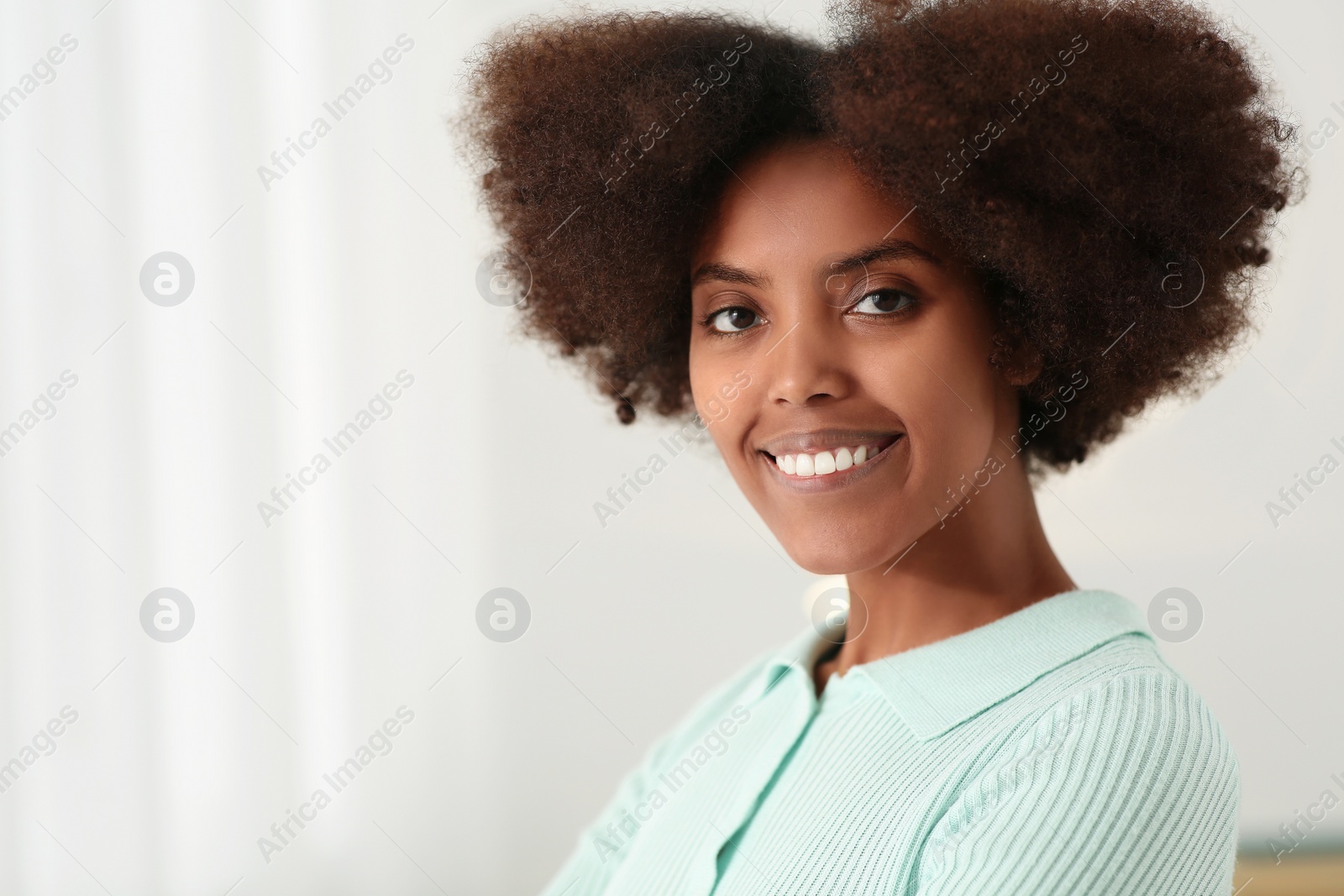 Photo of Portrait of smiling African American woman at home. Space for text