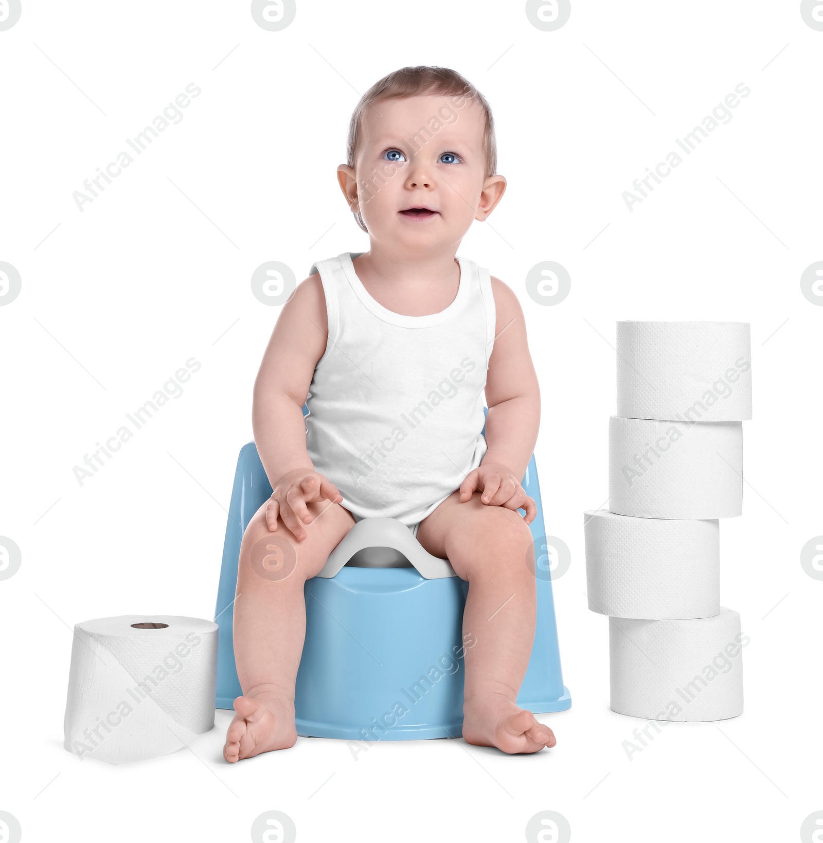 Photo of Little child sitting on baby potty and stack of toilet paper rolls against white background