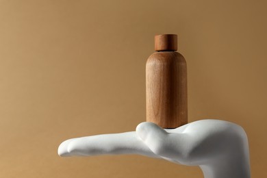 Composition with wooden bottle of cosmetic product on dark beige background, space for text