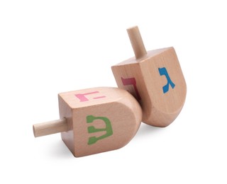 Photo of Wooden dreidels isolated on white. Traditional Hanukkah game
