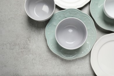 Beautiful ceramic dishware on light grey table, flat lay. Space for text