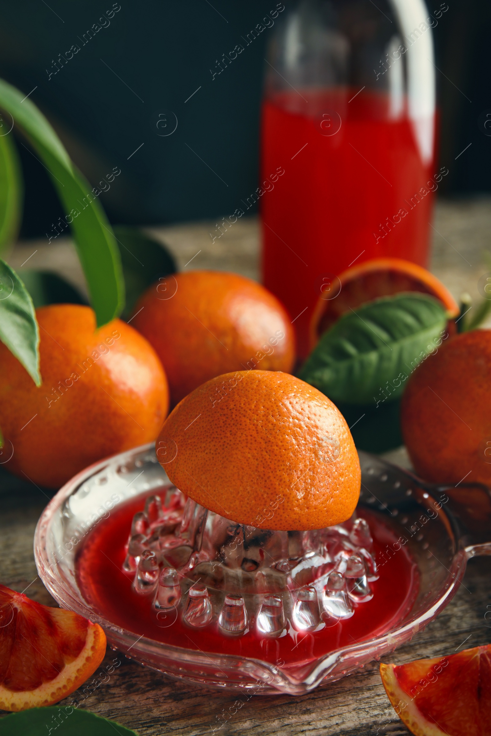 Photo of Squeezer with half of sicilian orange on wooden table