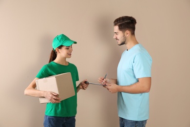 Photo of Client receiving parcel from delivery service courier on color background