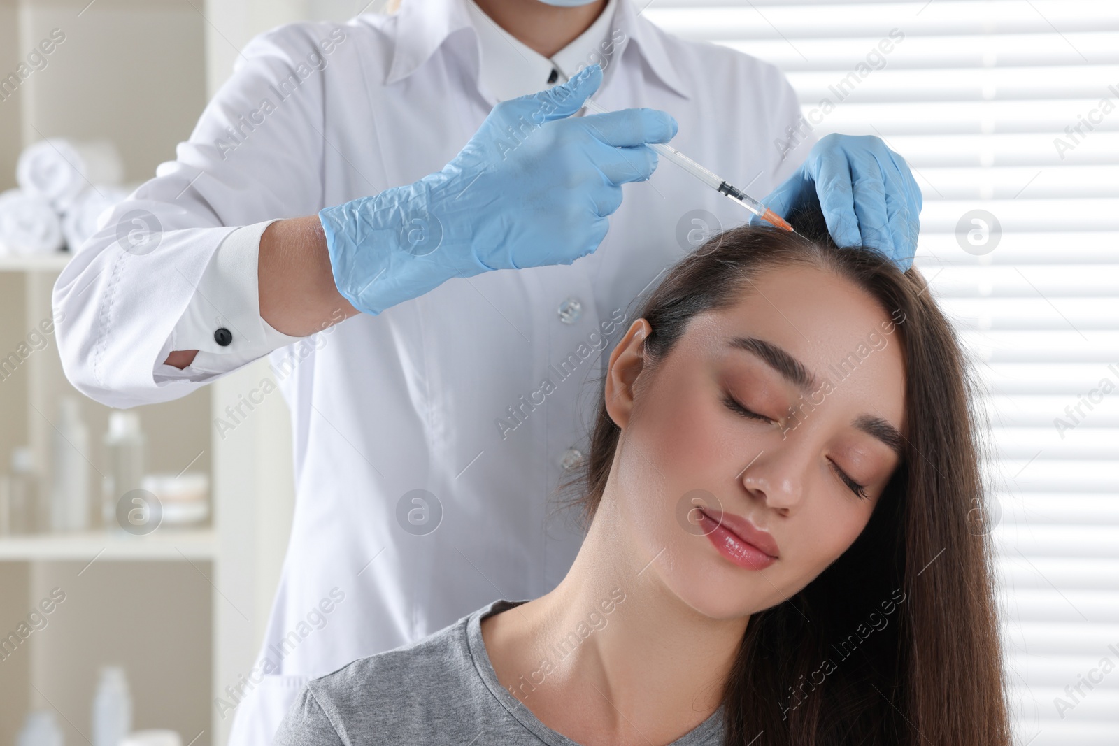 Photo of Trichologist giving injection to patient in clinic, closeup