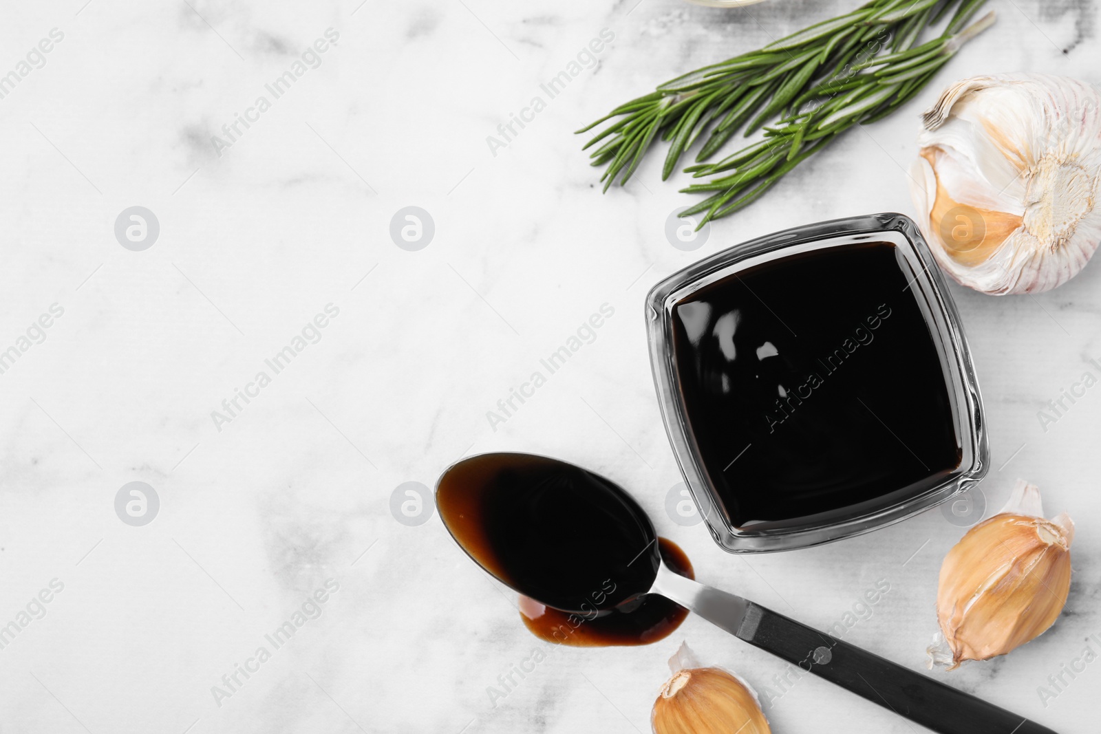 Photo of Organic balsamic vinegar and cooking ingredients on white table, flat lay. Space for text