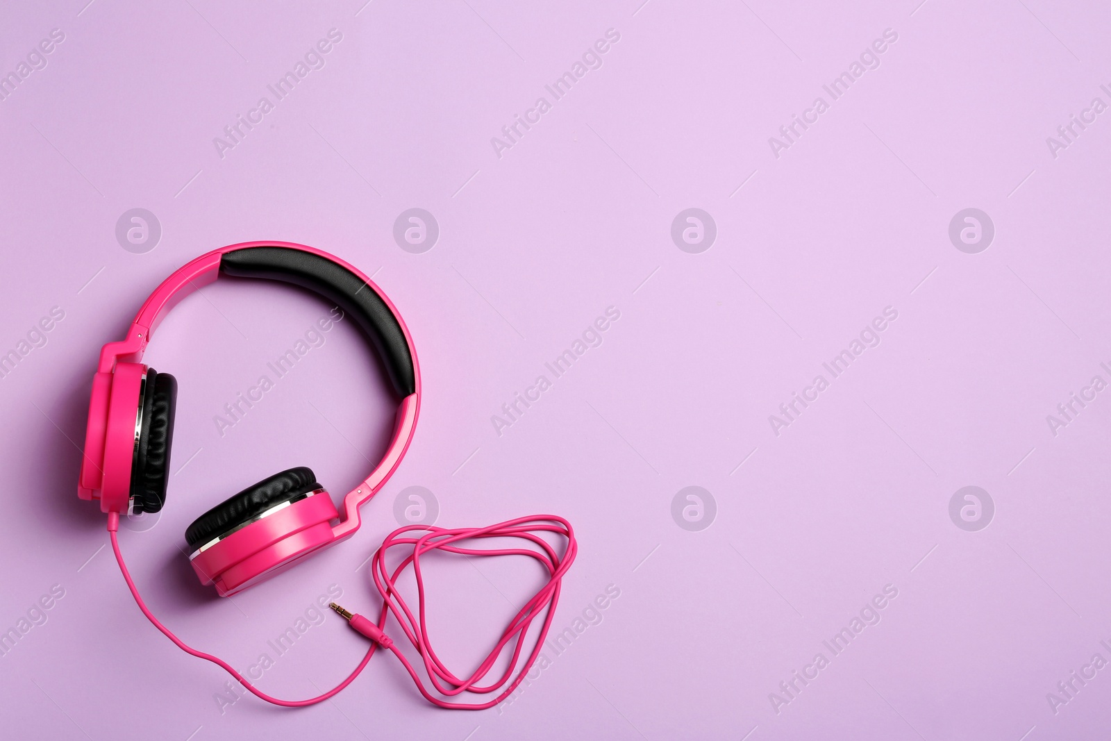 Photo of Stylish headphones on color background, top view. Space for text