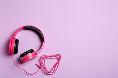 Stylish headphones on color background, top view. Space for text