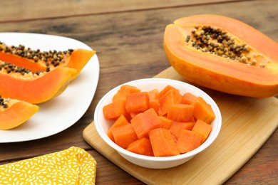 Tasty cut papaya fruits on wooden table